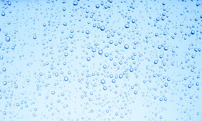 Blue background of water drops on glass or rain drop