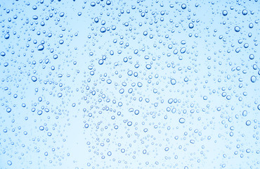 Blue background of water drops on glass or rain drop