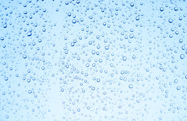 Fototapeta na wymiar Blue background of water drops on glass or rain drop