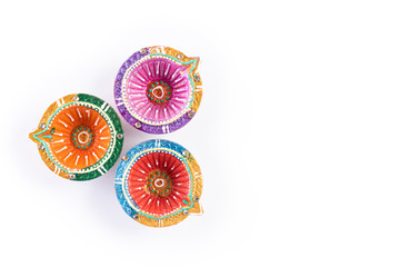Happy Diwali - Clay Diya lamps lit during Dipavali, Hindu festival of lights celebration. Colorful traditional oil lamp diya on white background