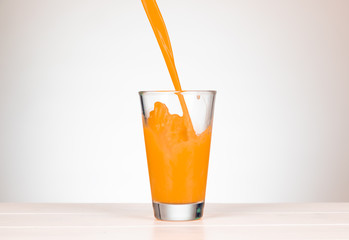 pour multivitamin juice in a glass with splashing