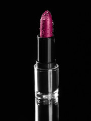 Pink lippenstift mit wassertropfen auf schwarzem hintergrund, professonelles kosmetik-produkt, make-up