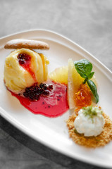 gourmet mango ice cream with redcurrant sauce dessert on plate