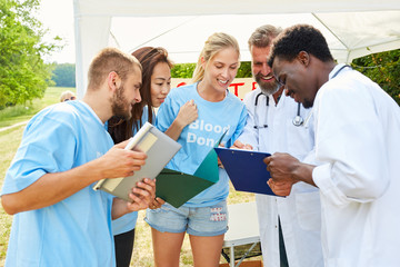 Volunteers discuss a blood donation action