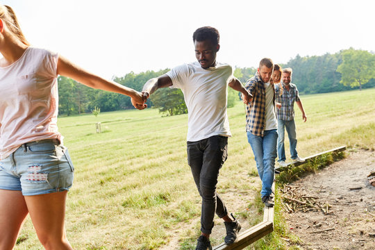 Group of young people is balancing together