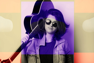 Portrait of a teenager with guitar in studio.