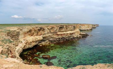 Fototapeta na wymiar Panorama of sea coast with steep textured limestone rocks