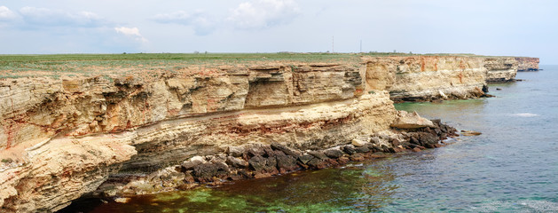 Panorama of steep textured limestone rocks of sea coast