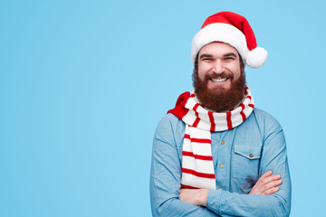 Fototapeta na wymiar Confident man in Christmas hat looking at camera