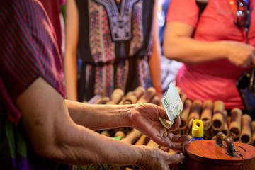 hands of elderly person with money who just bought a sugar cane