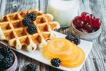 Petit déjeuner sain avec lait gaufre mûres du jardin et fruits confits