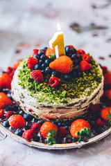 Birthday cake with one year figure and fresh fruits