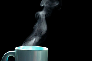 The steam from a cup of coffee or tea on the old wood table and black background, Warm drinks make good healthy, Selective focus.