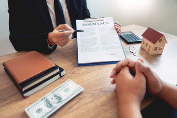 buy or sell real estate concept, Sale representative offer house purchase contract to buy a house or apartment and give home key chain to customer.