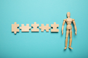 Wooden figure and puzzles, problem solving in business, new challenges. Innovation and teamwork.