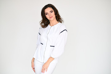 Concept photo portrait of a cute pretty beautiful brunette girl with great makeup in white clothes on a white background. In different poses with emotions.