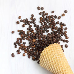 coffee beans spilled from a waffle cone onto a table top view. fireworks of taste
