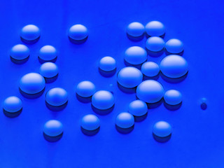 White bright drops shining in the liquid