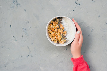 Bowl of homemade granola with yogurt and chia seeds on stone background from top view. Breakfast...