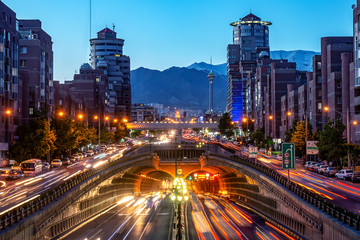 Fototapeta na wymiar 06/05/2019 Tehran,Iran,Famous night view of Tehran,Flow of traffic round Tohid Tunnel with Milad Tower and Alborz Mountains in Background, Tohid Tunnel one of longest urban tunnel in Middle East