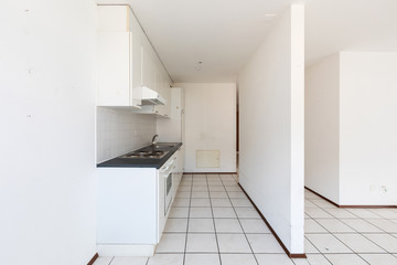 Empty room with vintage kitchen, white tiles and walls
