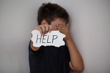 Upset abused frightened little child , stop hand gesture close up horizontal dark portrait with...