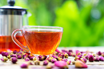 Damask rose bud,tTea for holistic health,tea made from tea rose petals in a glass  on wooden background