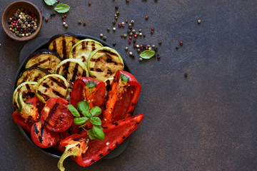 Frying pan with grilled vegetables on a stone background. View from above. Picnic. Barbecue.