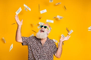 Fotobehang Portrait of crazy funky funny old bearded man hipster in green eyeglasses eyewear look up at money falling scream win lottery wear leopard stylish shirt isolated over yellow background © deagreez