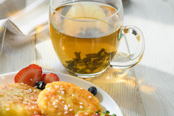 cheesecakes with honey tea and berries on a wooden table