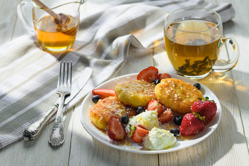 cheesecakes with honey tea and berries on a wooden table