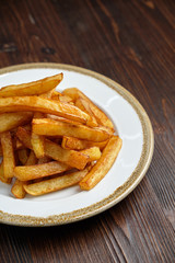 French fries on a white round plate. Restaurant menu