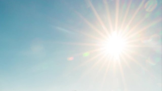 Beautiful sun with scenery sun rays and lens flare in blue sky. 4k Time lapse
