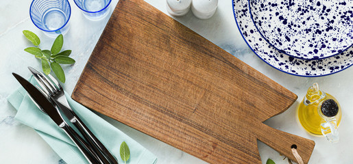 banner of wooden cutting or serving board on a marble table. copy space. shot from above