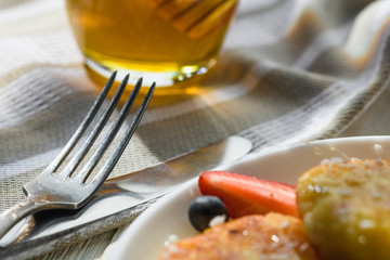 cheesecakes with honey tea and berries on a wooden table