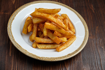 French fries on a white round plate. Restaurant menu
