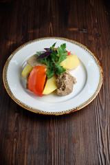 Boiled meat with a side dish and vegetables . restaurant menu