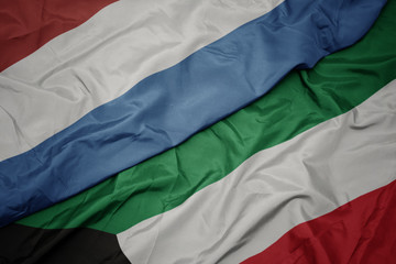 waving colorful flag of kuwait and national flag of luxembourg.