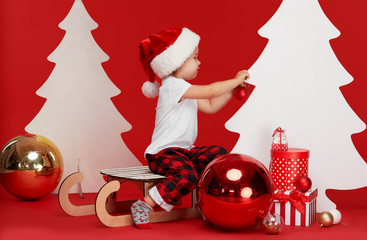 Merry Christmas and Happy Holidays! Cute little child girl is decorating the Christmas tree...