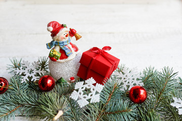 christmas composition with snowman, present box and pine branches on wooden background/ Christmas card with rustic decorations, copy space