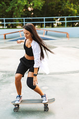 Teenager girl skater in park outdoors on skateboard. © Drobot Dean