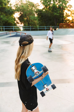 Back view photo of a blonde young teenager girl skater
