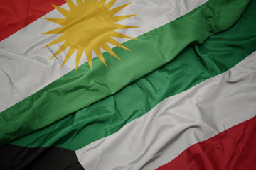 waving colorful flag of kuwait and national flag of kurdistan.