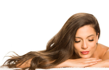 Naklejka premium Sensual portrait of a young beautiful woman with long hair, lying on a white background
