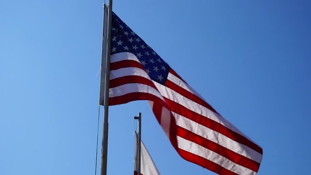 The flag of the United States flashes in the wind.