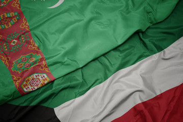 waving colorful flag of kuwait and national flag of turkmenistan.