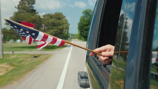 Hand with US flag in a car window. Travel Scandinavia Concept