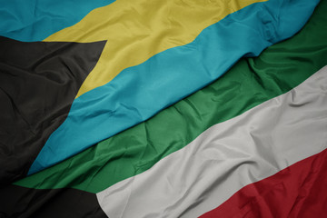 waving colorful flag of kuwait and national flag of bahamas.