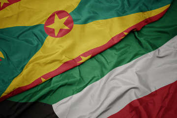 Obraz premium waving colorful flag of kuwait and national flag of grenada.