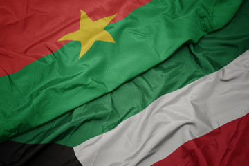 waving colorful flag of kuwait and national flag of burkina faso.